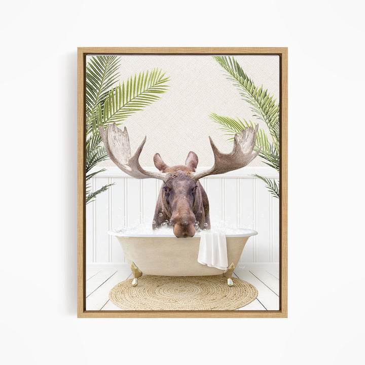 A moose with large antlers is sitting in a bathtub filled with water, surrounded by palm leaves and a woven rug.
