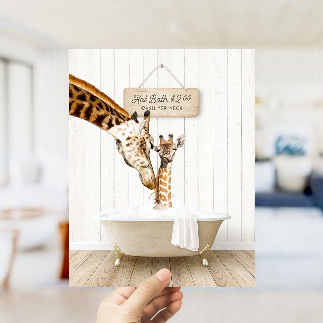 A hand holds up a framed image of a giraffe and a baby giraffe standing in a bathtub, with a sign above them that reads "Hot Bath $2.00 Wash neck".