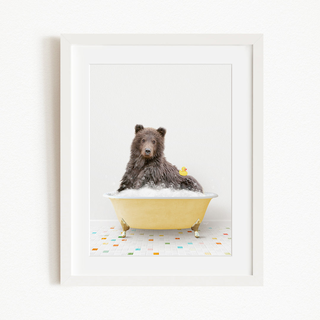 A brown bear sitting in a yellow bathtub filled with bubbles, with a yellow rubber duck floating on the water.
