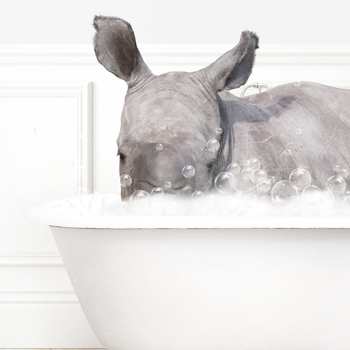 a rhino laying down in a bathtub with bubbles