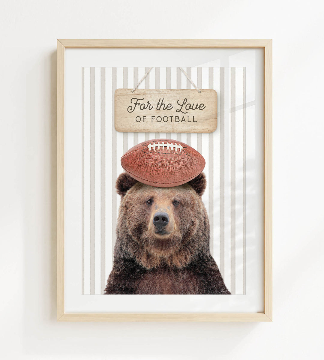 A framed image of a brown bear wearing a football helmet and standing in front of a sign that says "For the Love of Football".