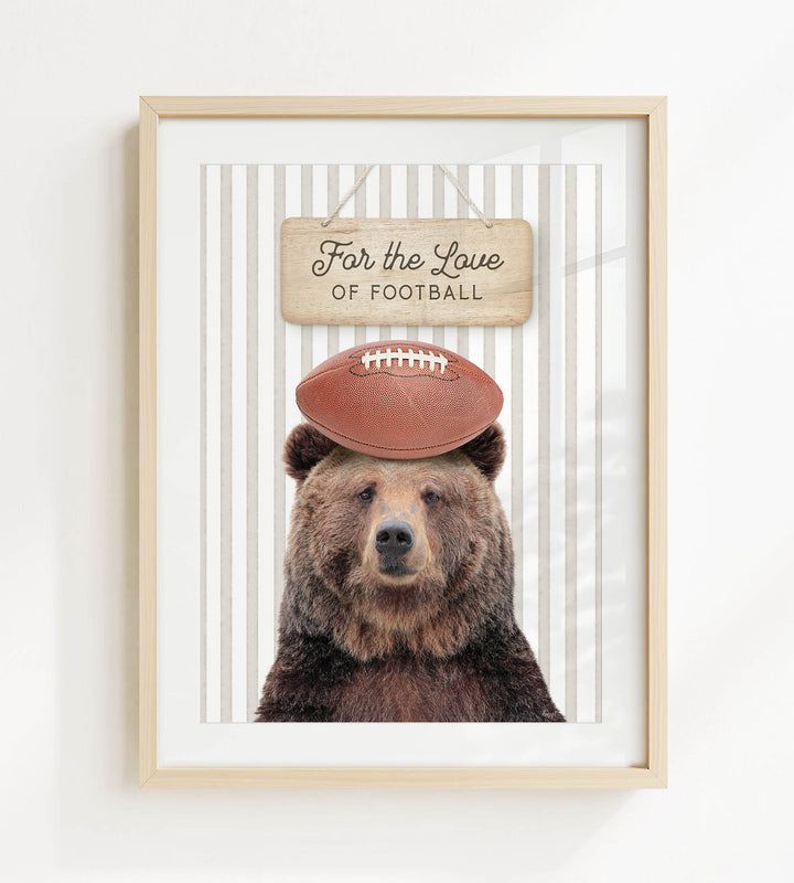 A framed image of a brown bear wearing a football helmet and standing in front of a sign that says "For the Love of Football".