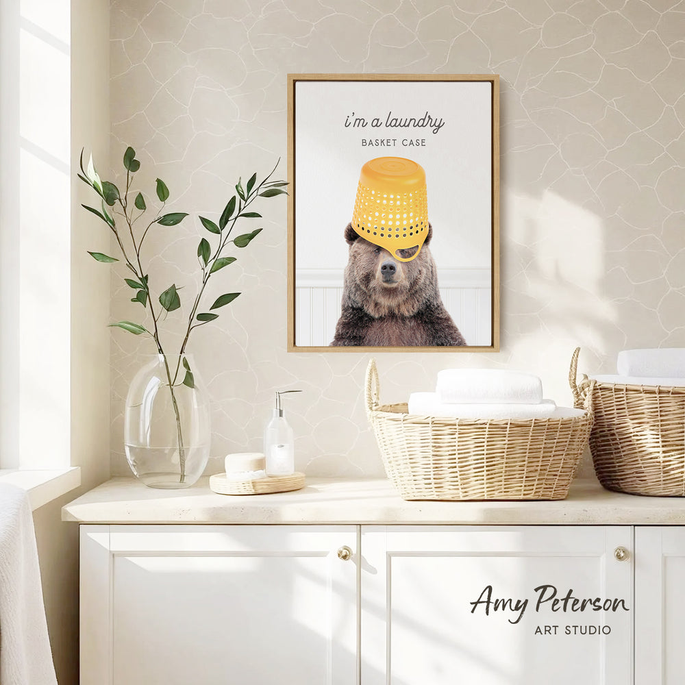 a framed picture of a bear wearing a yellow bucket hat, hanging on a wall above a white cabinet with baskets.