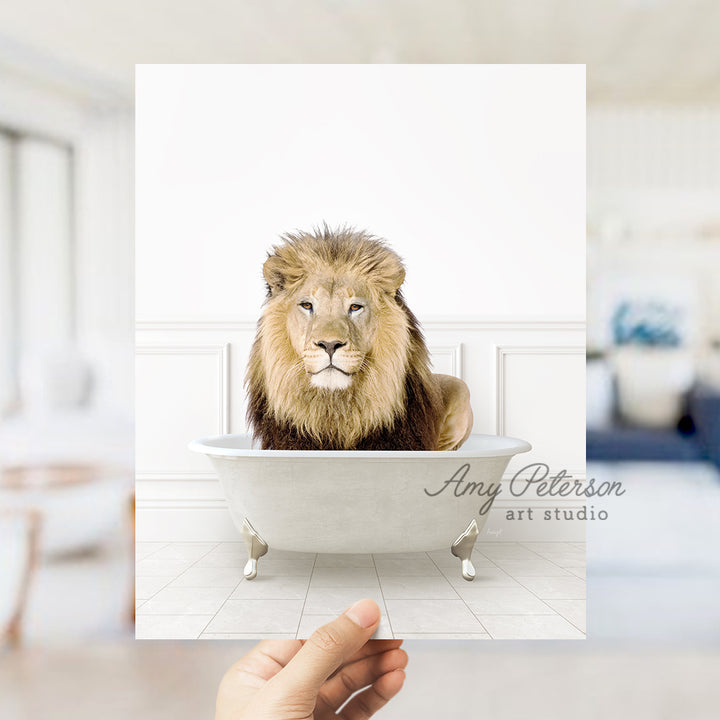 a hand holding a card with a lion in a bathtub