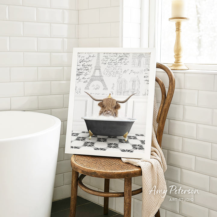 A framed image of a Highland cow sitting in a bathtub, surrounded by a tiled bathroom setting.