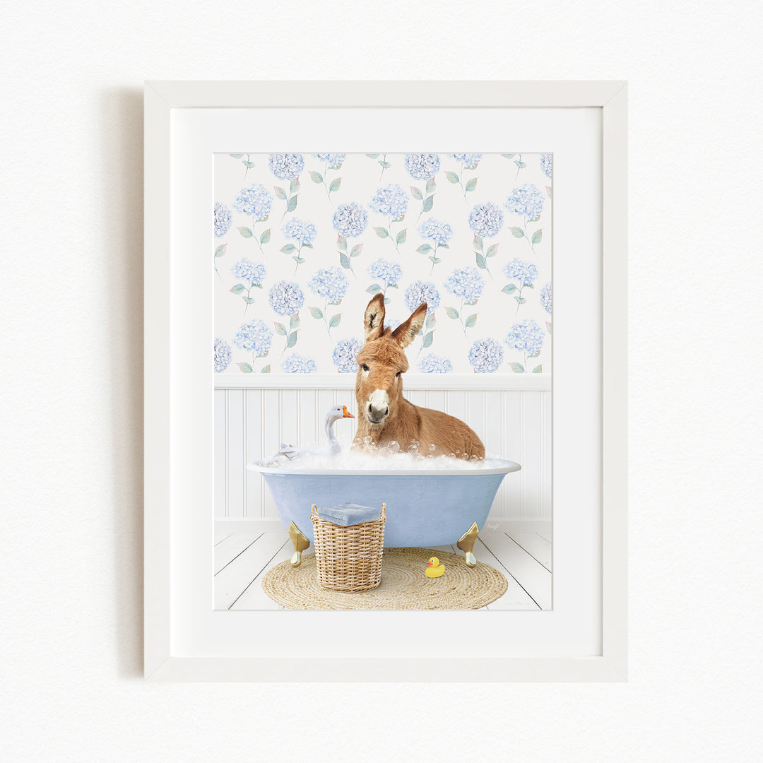 A donkey is sitting in a blue bathtub filled with bubbles, surrounded by various bath toys, including rubber ducks and a bird.