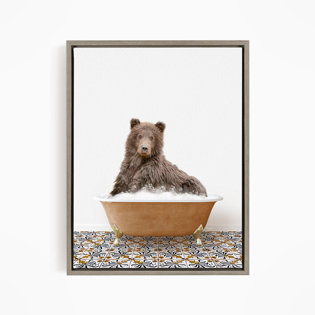 A brown bear sitting in a bathtub filled with bubbles, looking directly at the camera.