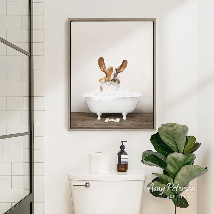 A framed image of a dog sitting in a bathtub, surrounded by bubbles, is displayed on the wall above a white toilet in a bathroom.