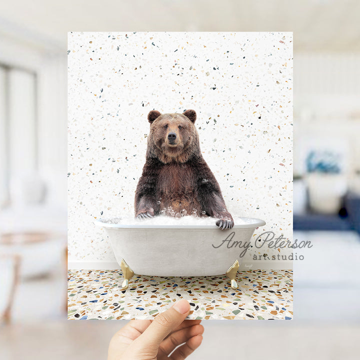 a person holding up a polaroid picture of a bear in a bathtub