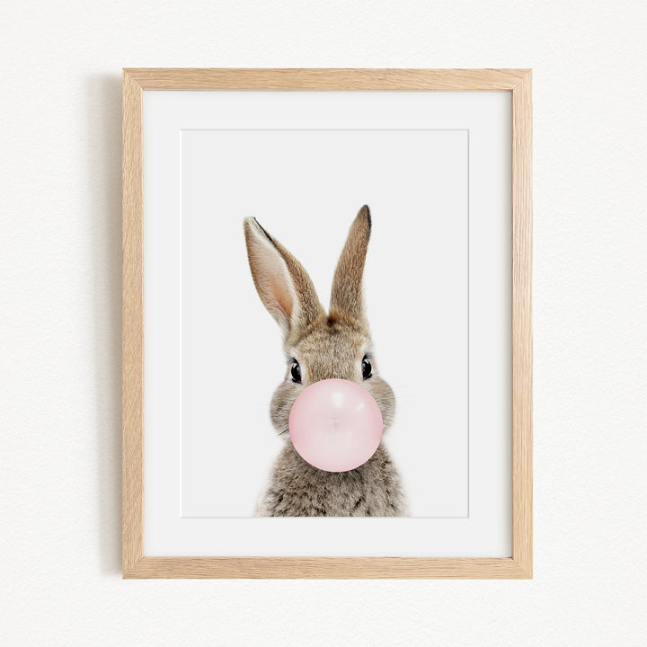 A cute rabbit blowing a bubble with a pink bubble gum bubble.