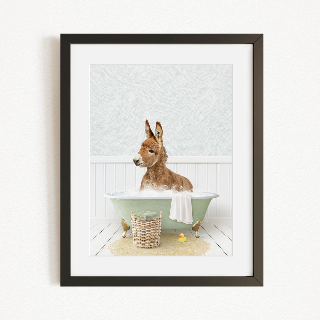 A donkey is sitting in a green bathtub filled with bubbles, surrounded by a basket of rubber ducks and a yellow rubber ducky.