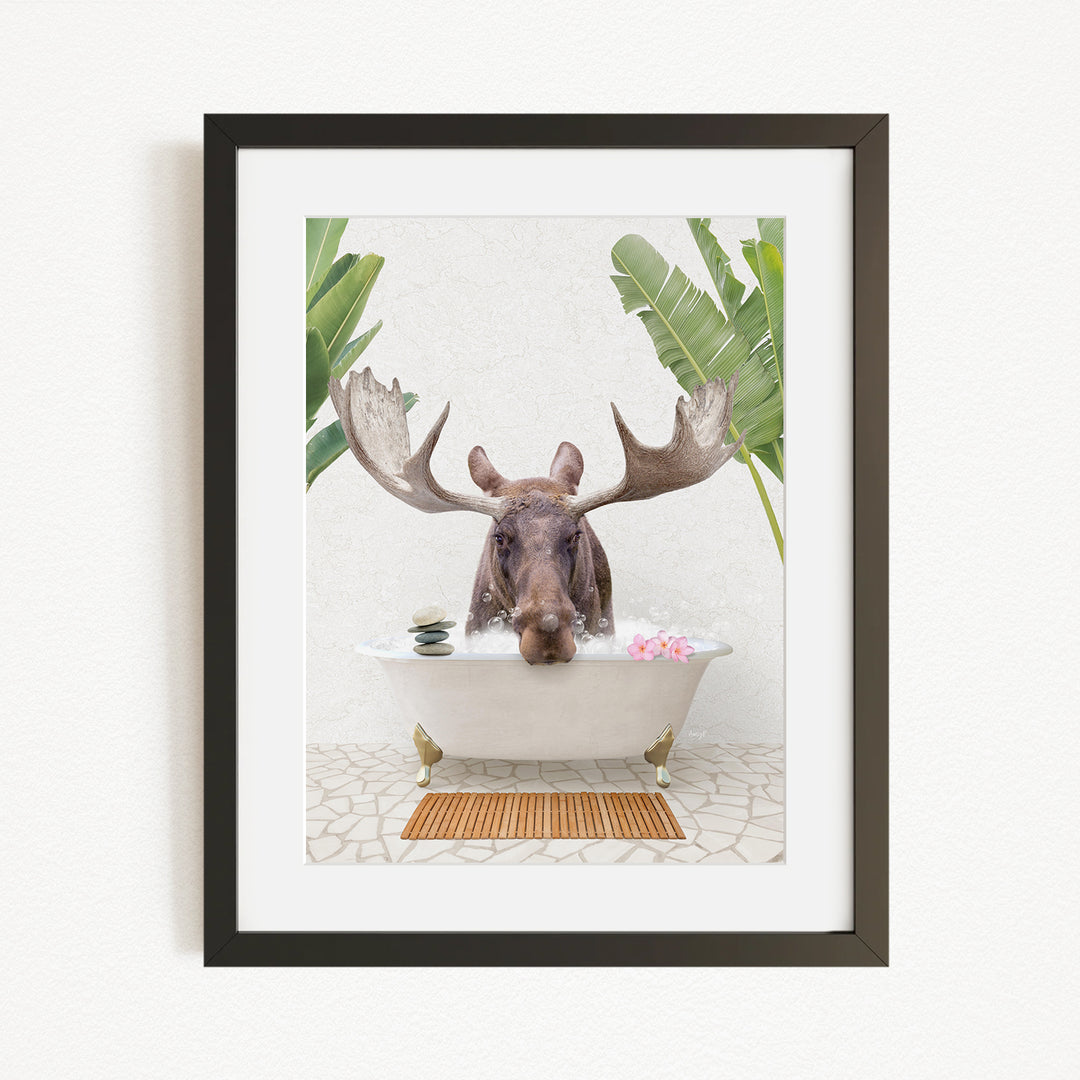 A moose with large antlers is sitting in a bathtub filled with pink flowers, surrounded by green plants.