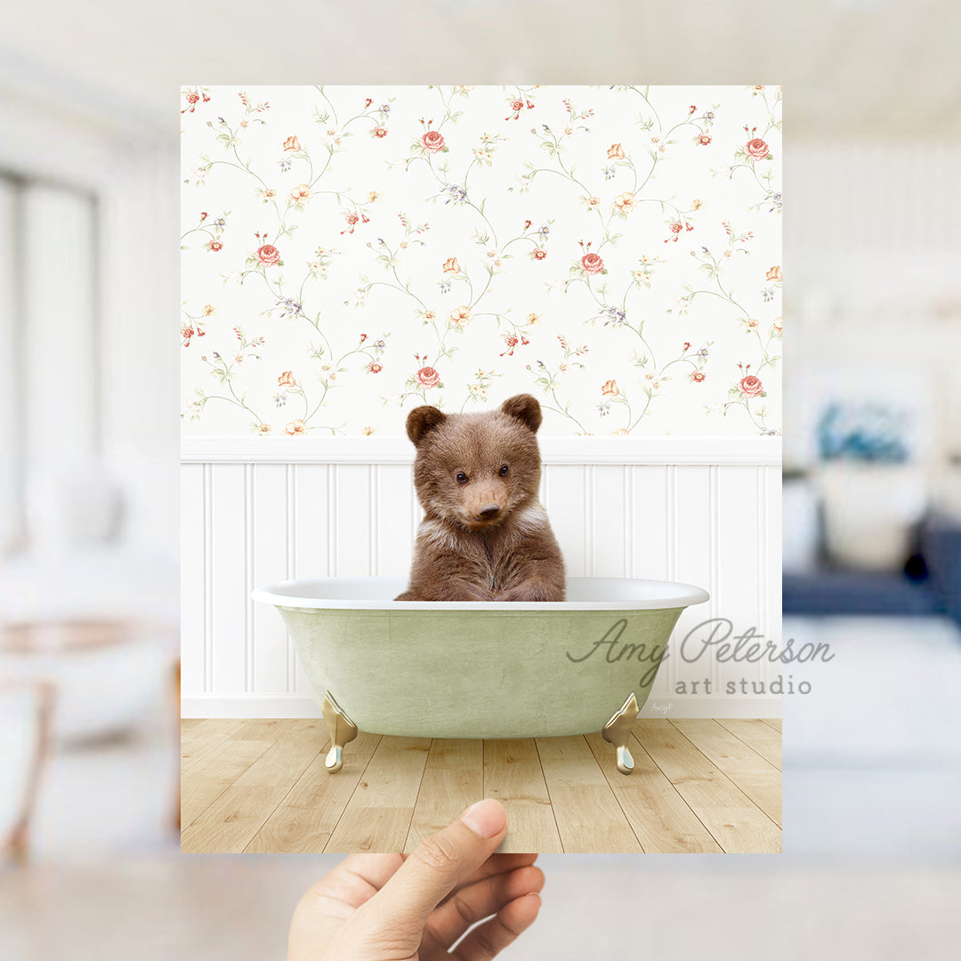 a person holding a polaroid with a bear in a bathtub