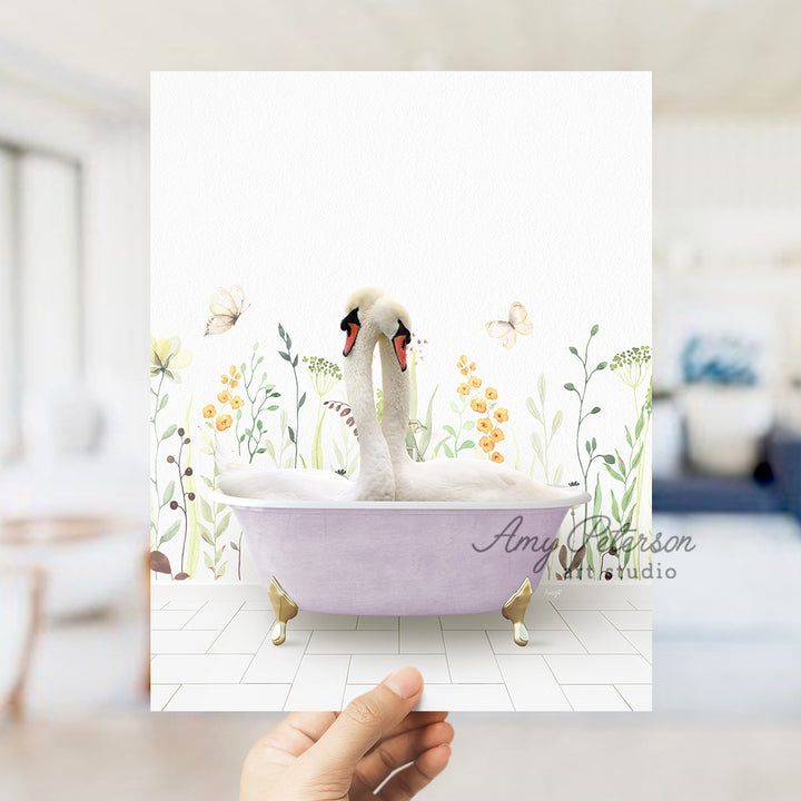 a person holding up a card with a picture of two swans in a bathtub