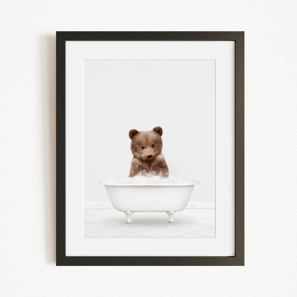 A cute brown bear sitting in a white bathtub filled with bubbles, creating a playful and whimsical scene.