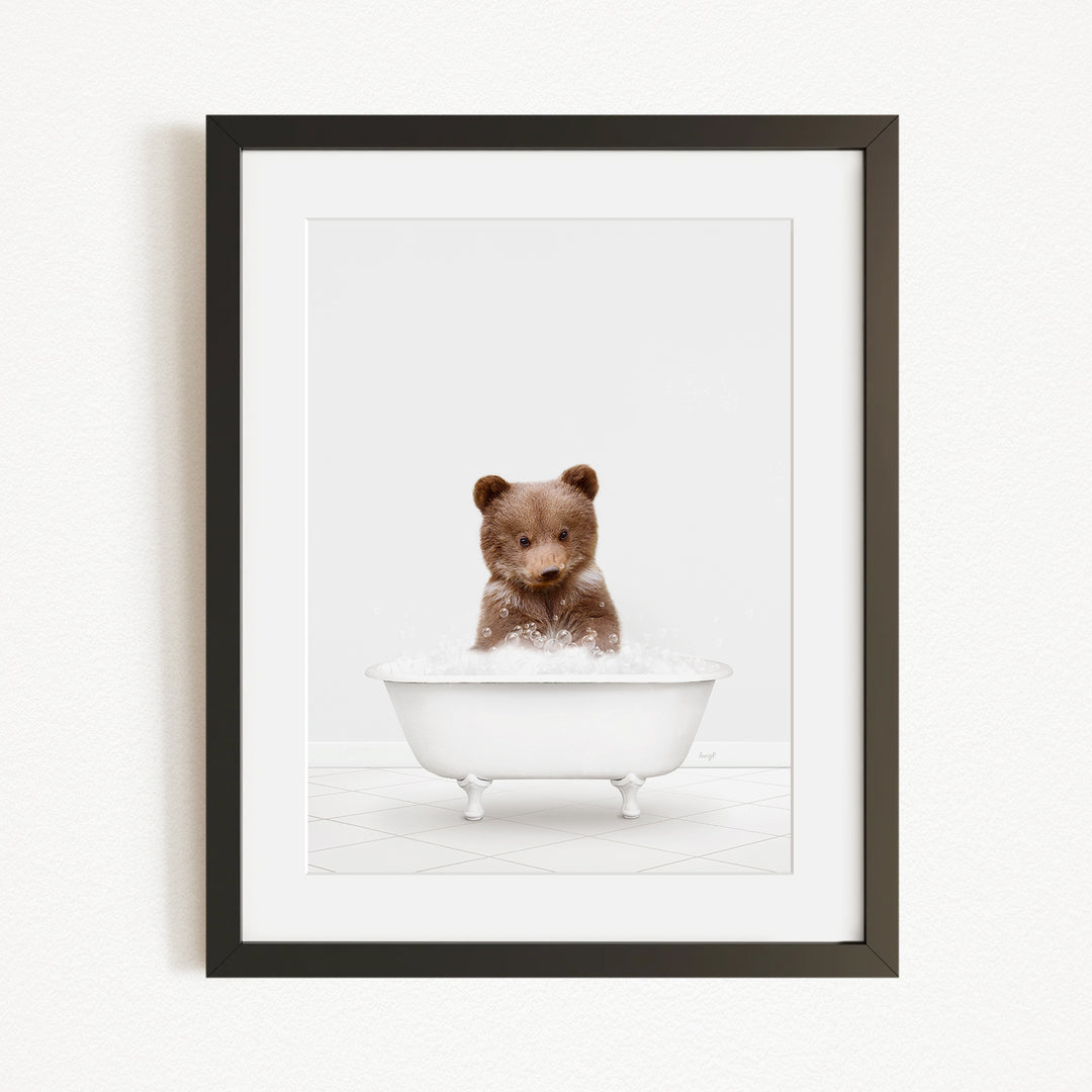 A cute brown bear sitting in a white bathtub filled with bubbles, creating a playful and whimsical scene.