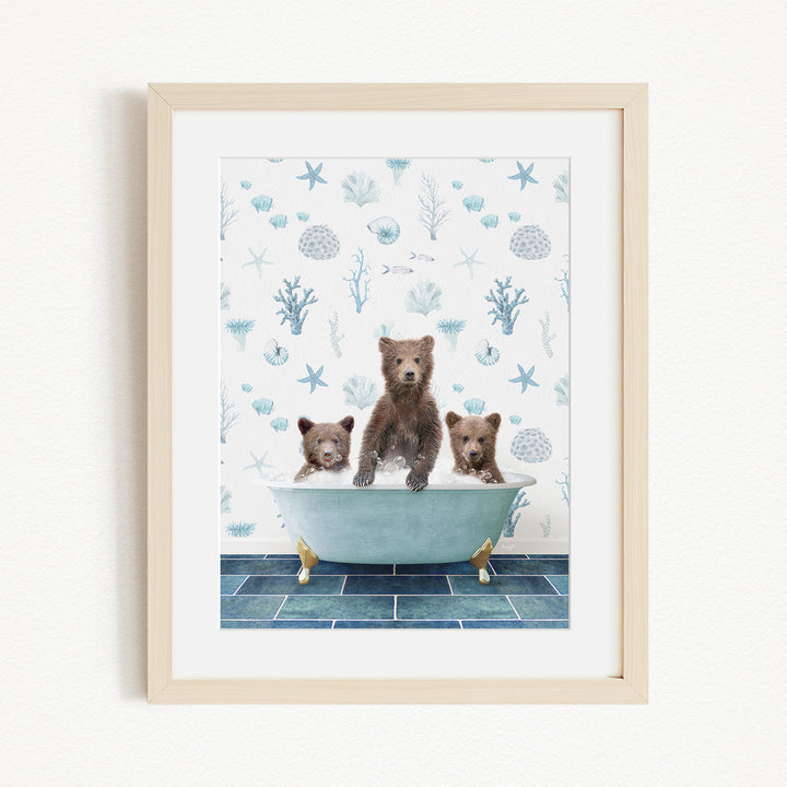 A framed image depicting three brown bears sitting in a bathtub filled with water, surrounded by a blue and white ocean-themed wallpaper.