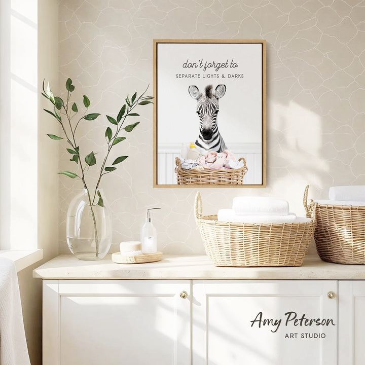 a framed poster of a zebra with a basket of baby animals, hanging on a wall above a white cabinet with baskets.