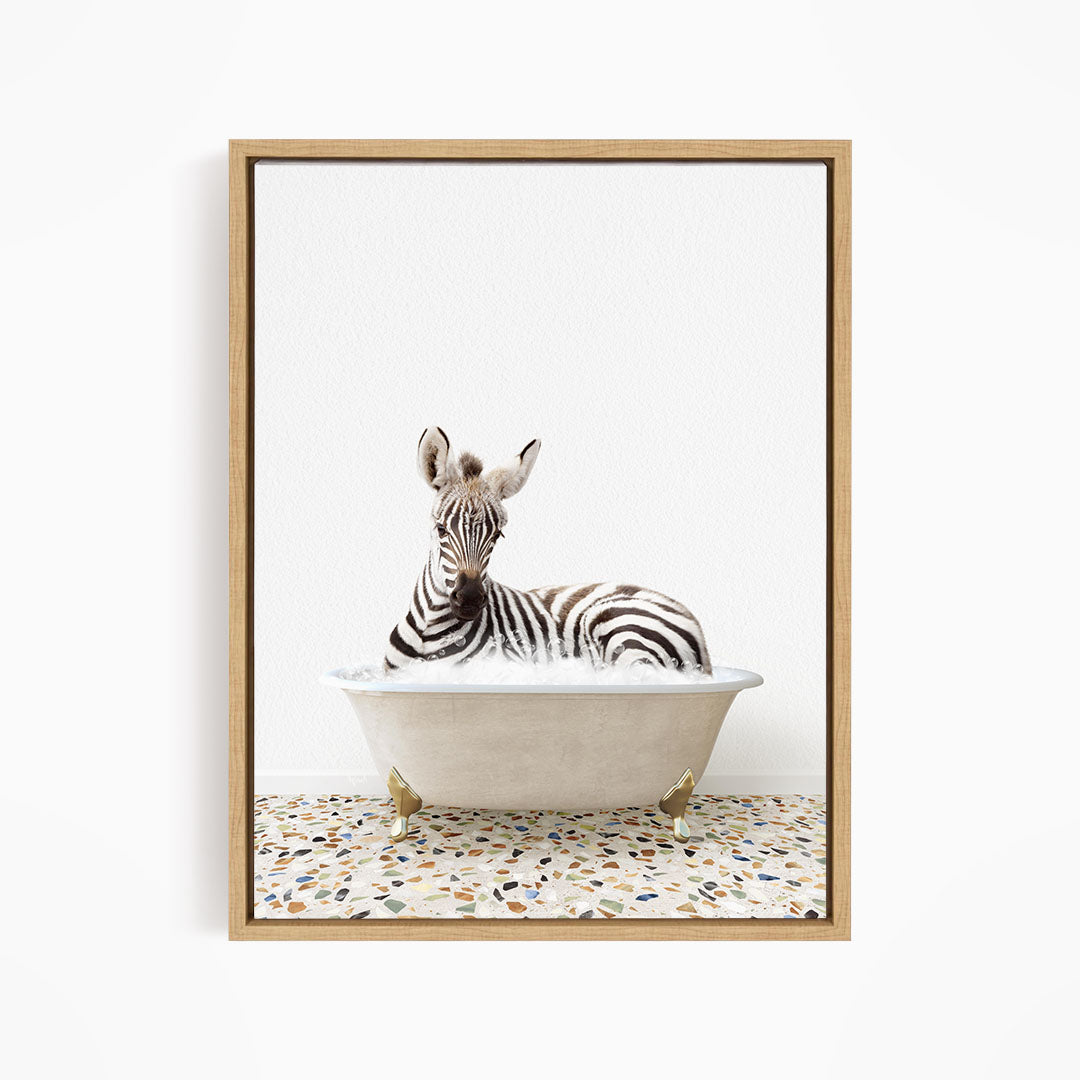 A zebra is sitting in a white bathtub, surrounded by a mosaic floor.