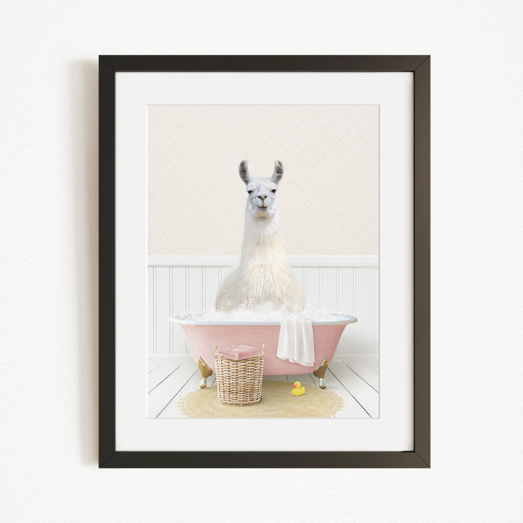 A white llama sitting in a pink bathtub, surrounded by a yellow rubber duck and a wicker basket.