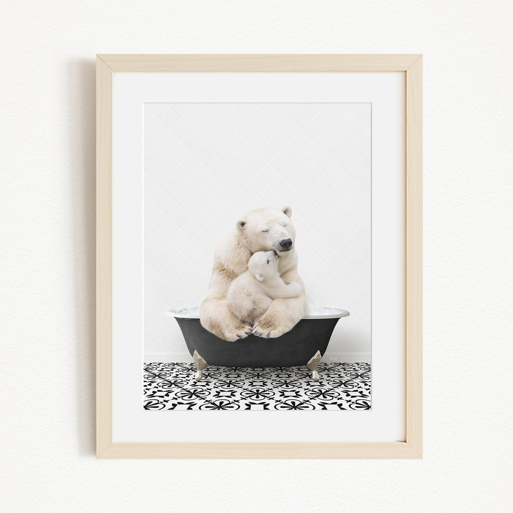 A framed image depicting two polar bears sitting in a bathtub, with one bear appearing to be hugging the other.
