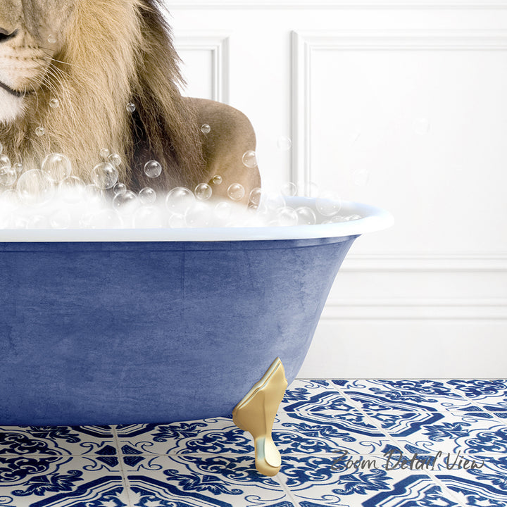 A lion is sitting in a blue bathtub filled with bubbles, with a gold-colored bathtub faucet and a patterned tile floor.