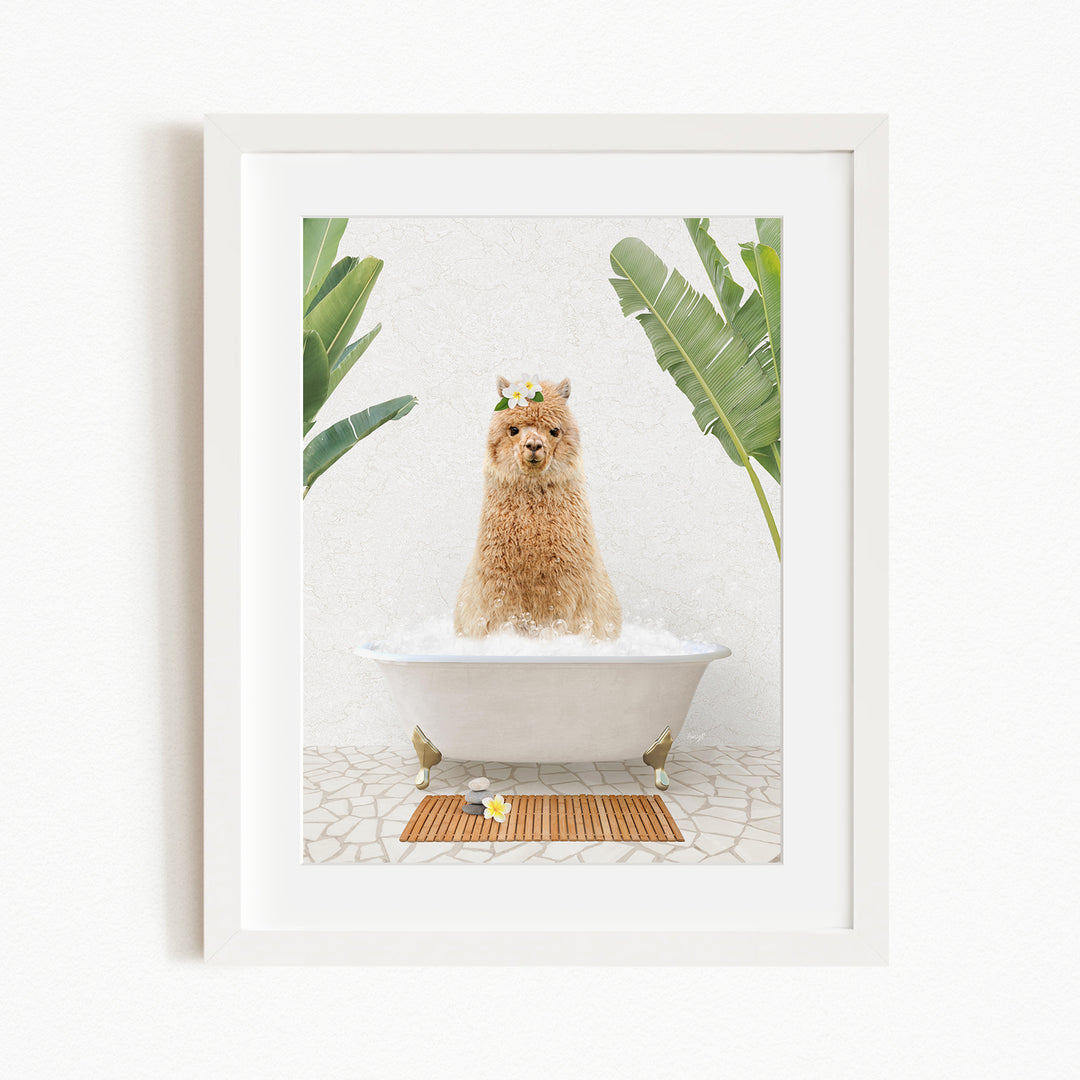 A brown alpaca sitting in a white bathtub filled with bubbles, surrounded by green plants and a wooden mat on the floor.