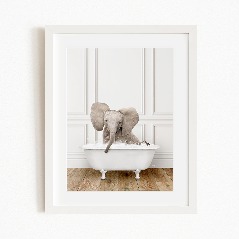 A baby elephant sitting in a white bathtub, with its trunk submerged in the water.