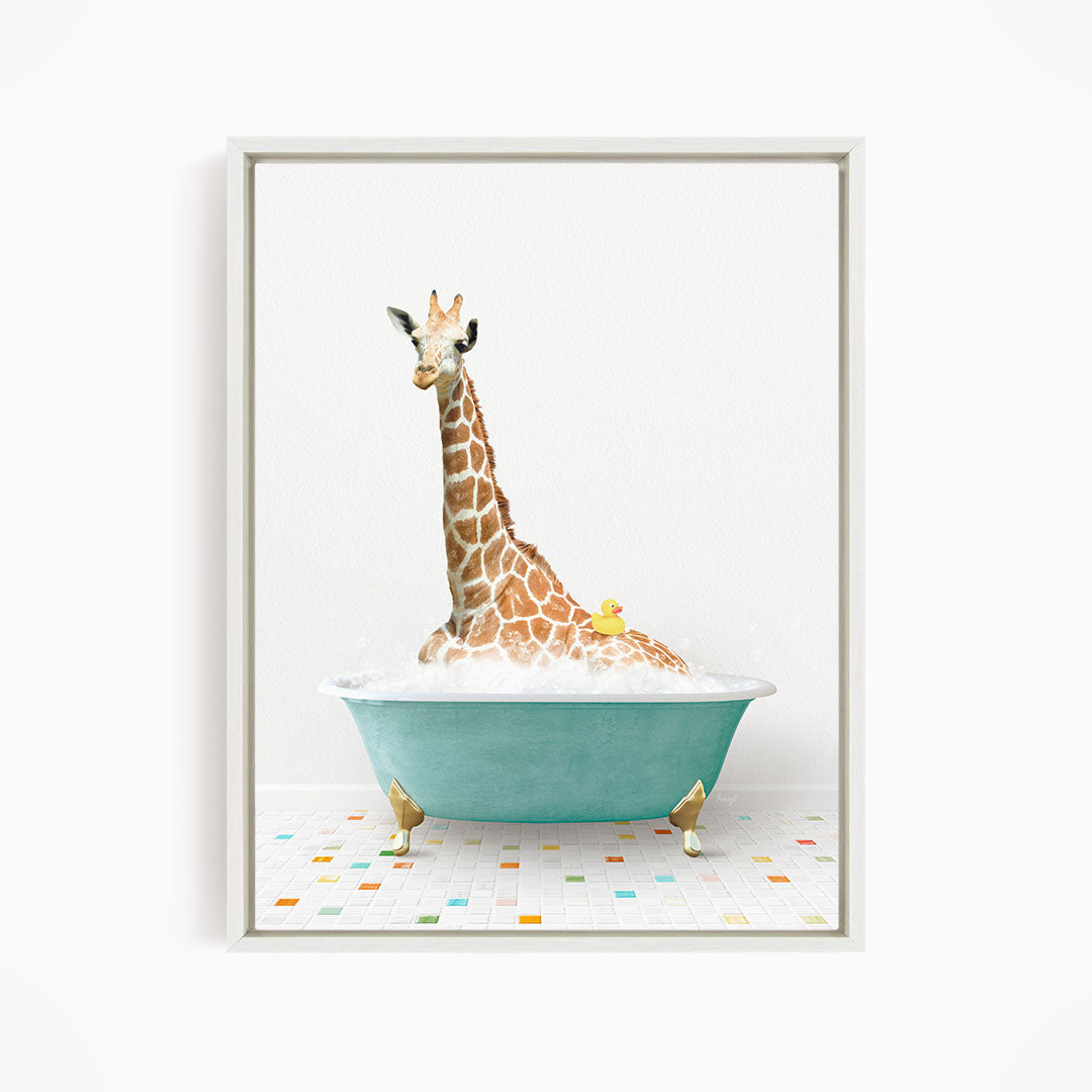 A giraffe is sitting in a blue bathtub filled with bubbles, with a yellow rubber duck floating on the water.