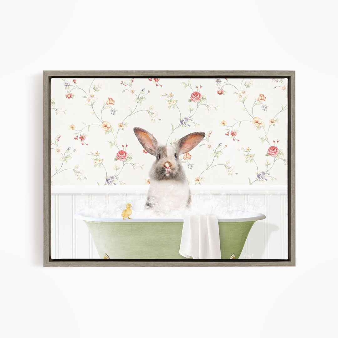 A fluffy gray rabbit sits in a green bathtub filled with bubbles, surrounded by a floral wallpaper.