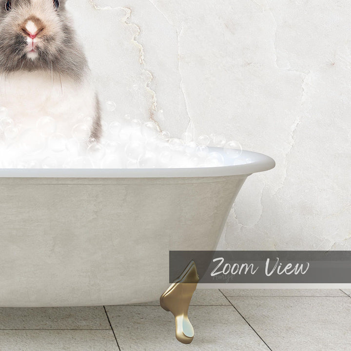 A fluffy gray and white rabbit sitting in a white bathtub filled with bubbles, with a gold bathtub faucet visible.