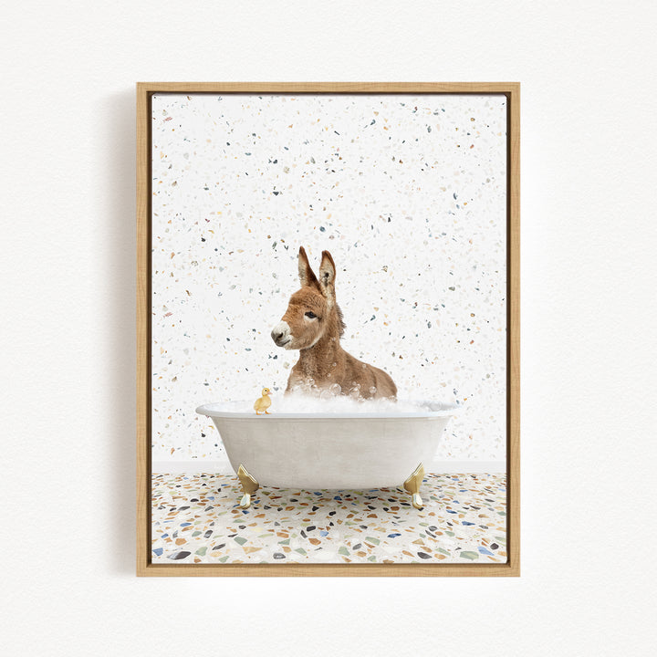 A donkey is sitting in a bathtub filled with water, surrounded by small yellow rubber ducks.