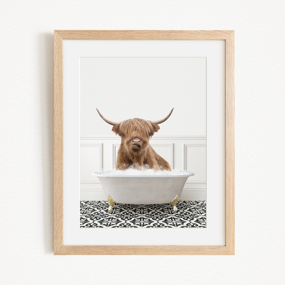 A Highland cow with long horns is sitting in a white bathtub filled with water, creating a whimsical and playful scene.