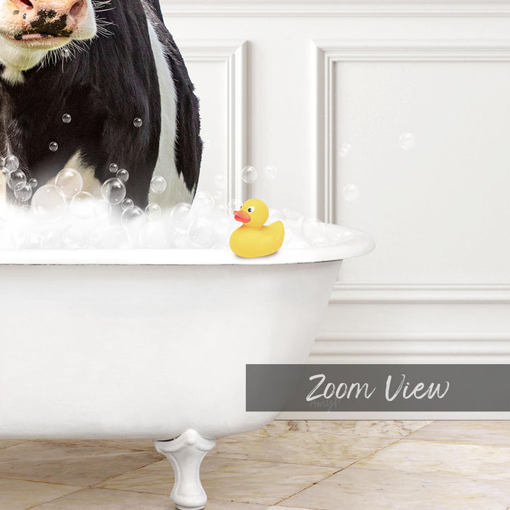 A black and white cow is standing in a white bathtub filled with bubbles, with a yellow rubber duck floating on the water.