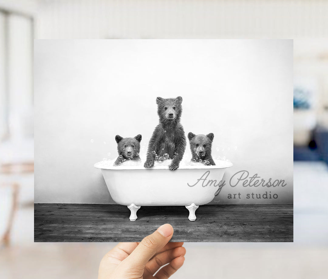 a black and white photo of three bears in a bathtub