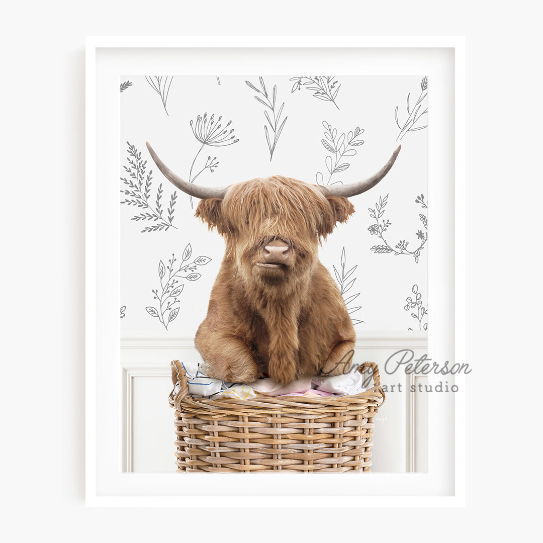 a picture of a highland cow sitting in a basket