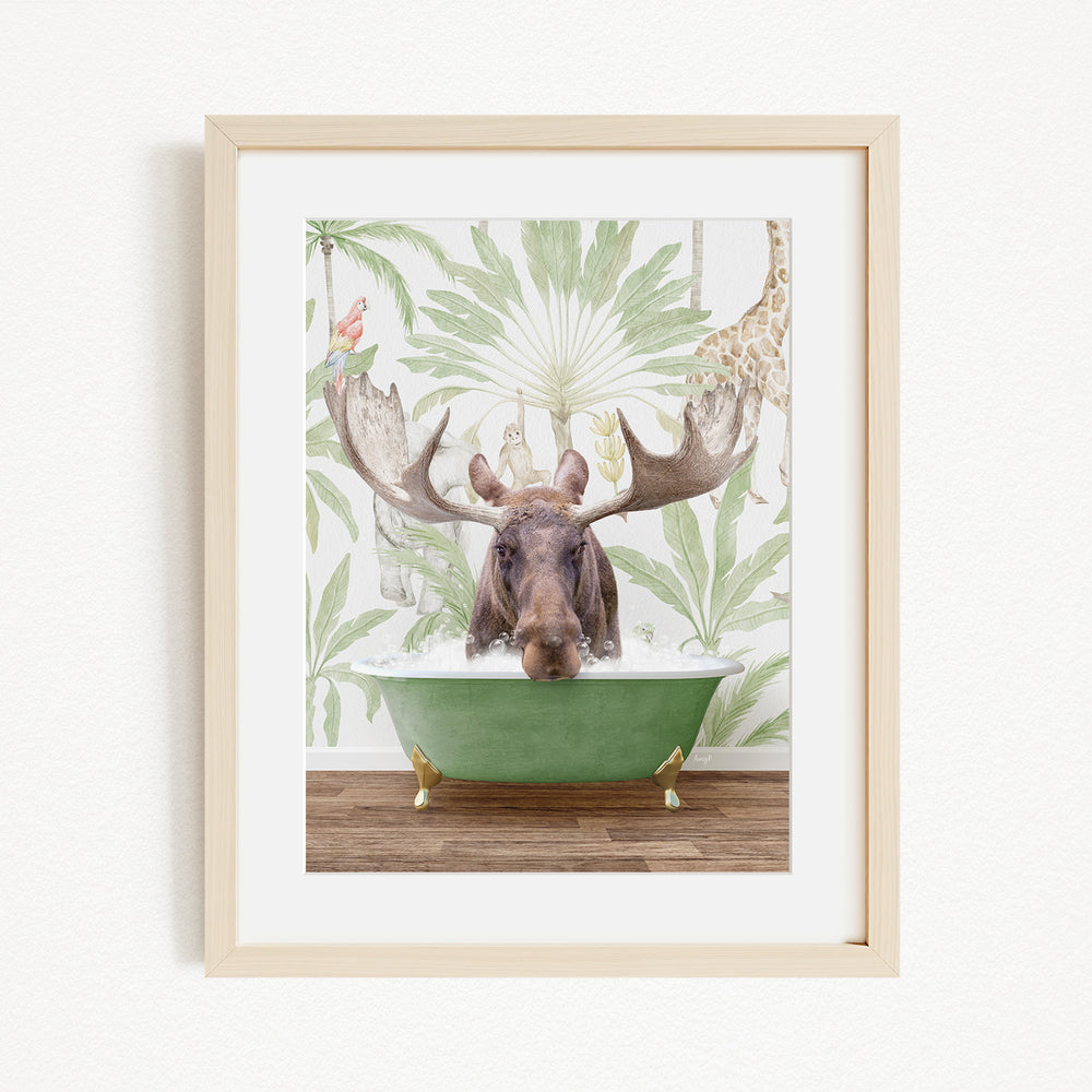 A moose with large antlers is sitting in a green bathtub, surrounded by a tropical wallpaper with palm trees and other animals.