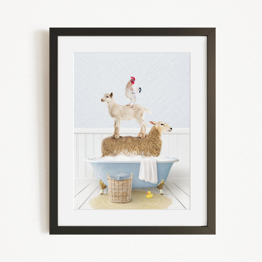 A framed image depicting a goat standing on a sheep's back while a rooster stands on top of the sheep, all in a bathtub.