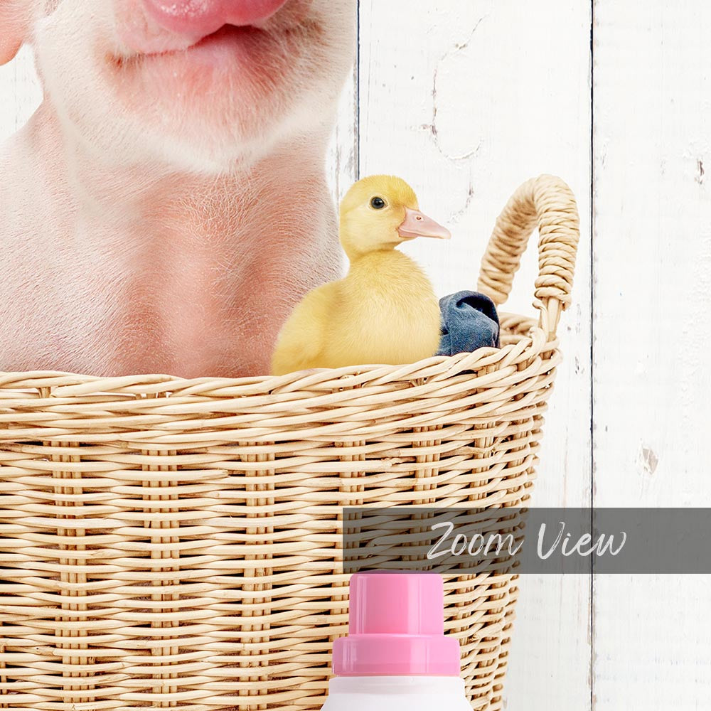 A small yellow duckling peeks out from a wicker basket, with a pink bottle and a white wall in the background.