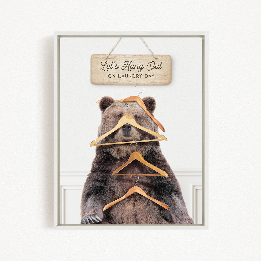 A framed image of a bear sitting in front of a sign that says "Let's Hang Out on Laundry Day".