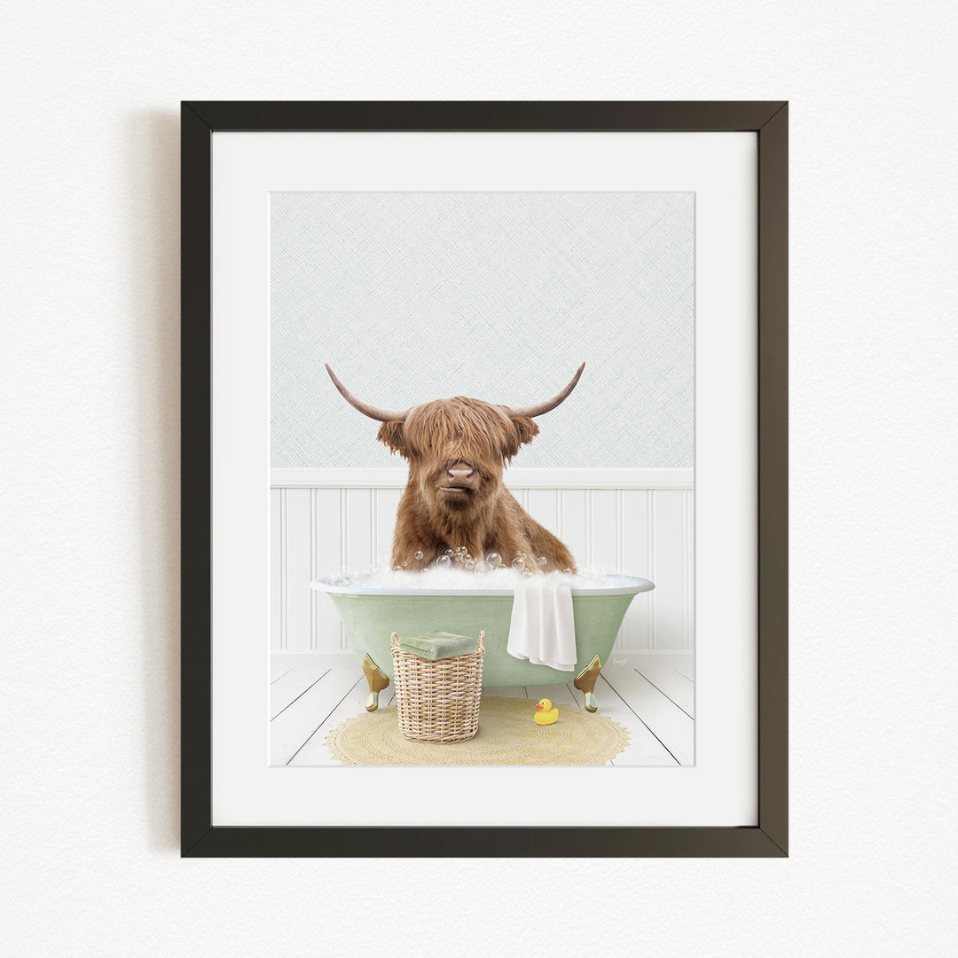 A Highland cow with long horns is sitting in a green bathtub, surrounded by a basket of rubber ducks and a yellow rubber ducky.