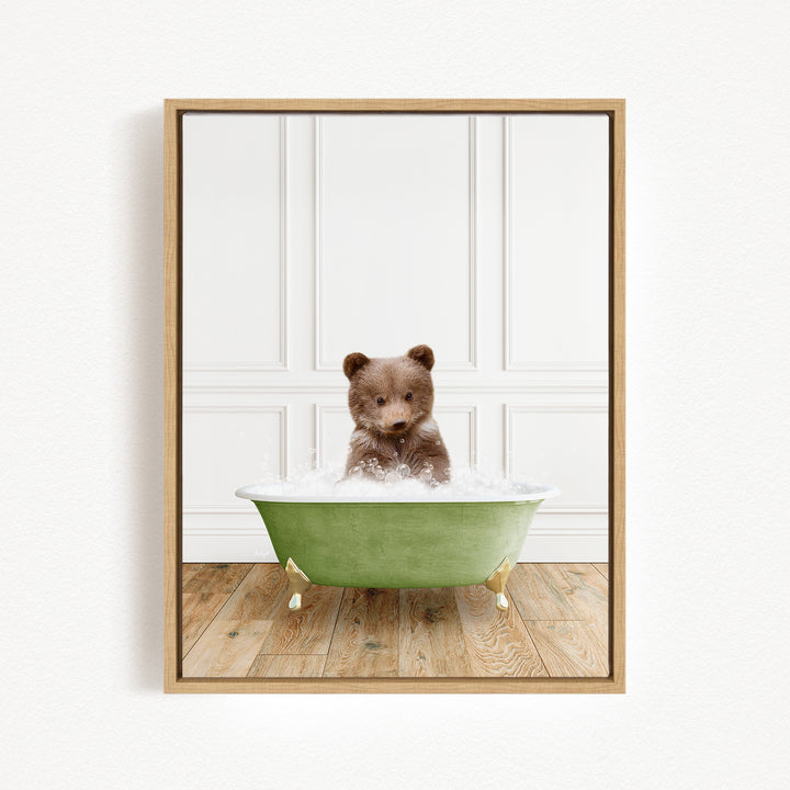 A small brown bear cub sitting in a green bathtub filled with water, looking at the camera.