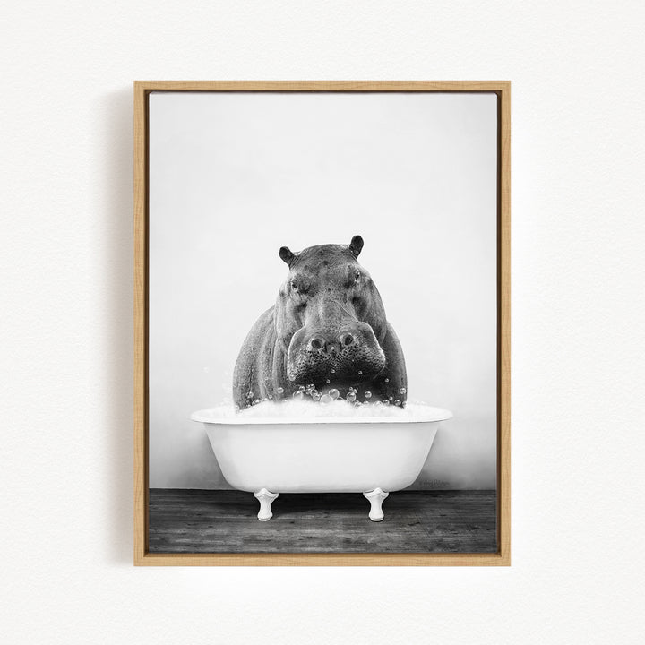 A black and white photograph of a hippopotamus sitting in a bathtub filled with water, creating a playful and whimsical scene.