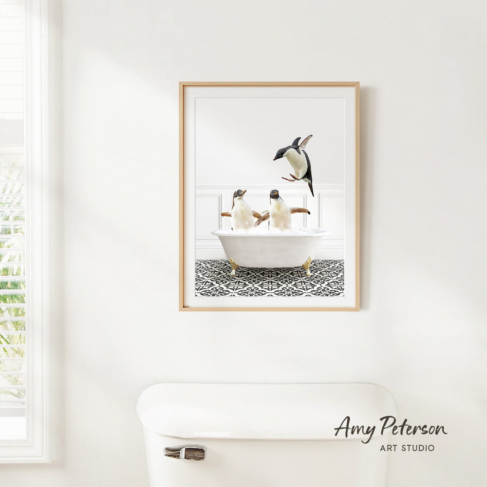 A framed image of two penguins sitting in a bathtub, with one penguin standing on the edge of the tub.