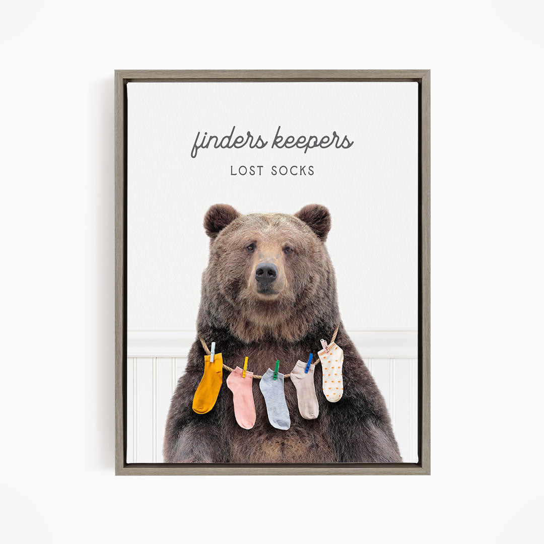 A brown bear wearing a variety of colorful socks hanging from clothespins.