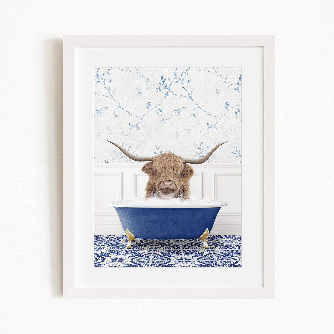 A brown cow with long horns is sitting in a blue bathtub, surrounded by a blue and white patterned rug and a white wall with blue floral wallpaper.