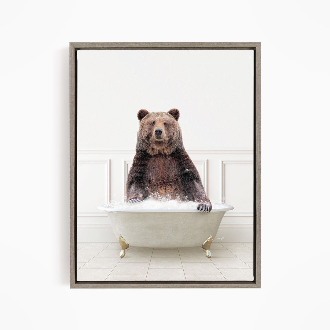 A brown bear sitting in a white bathtub filled with water, appearing to enjoy the bath.