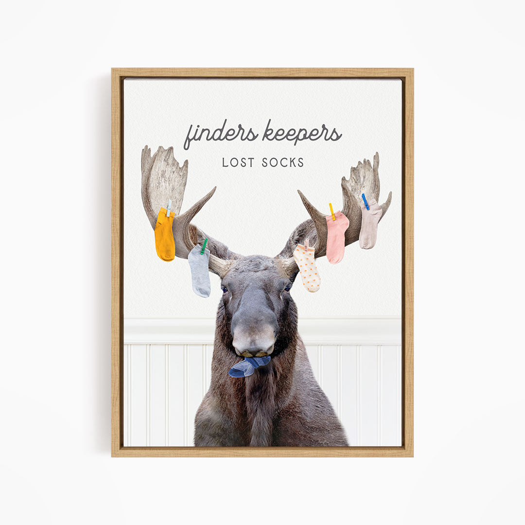 A moose with a pair of socks hanging from its antlers, with the text "finders keepers" and "lost socks" above the image.