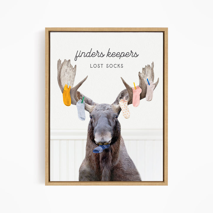 A moose with a pair of socks hanging from its antlers, with the text "finders keepers" and "lost socks" above the image.