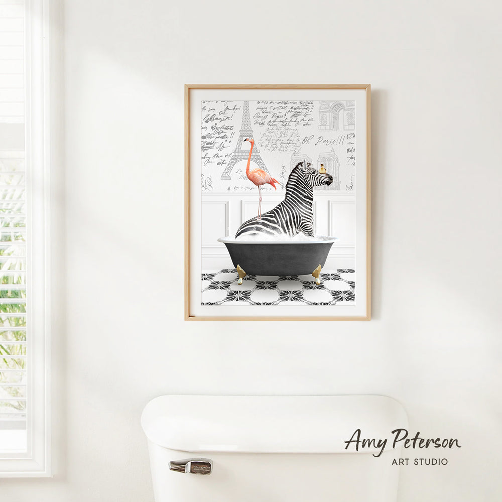 A framed illustration of a zebra sitting in a bathtub, with a pink flamingo standing on the edge of the tub.